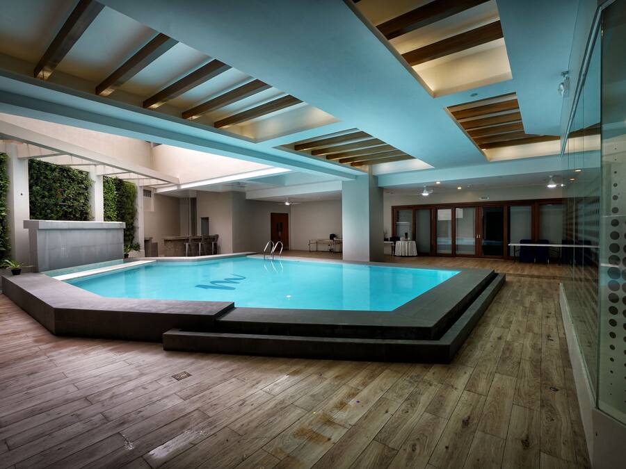 Una piscina techada, sillones reclinables de piscina