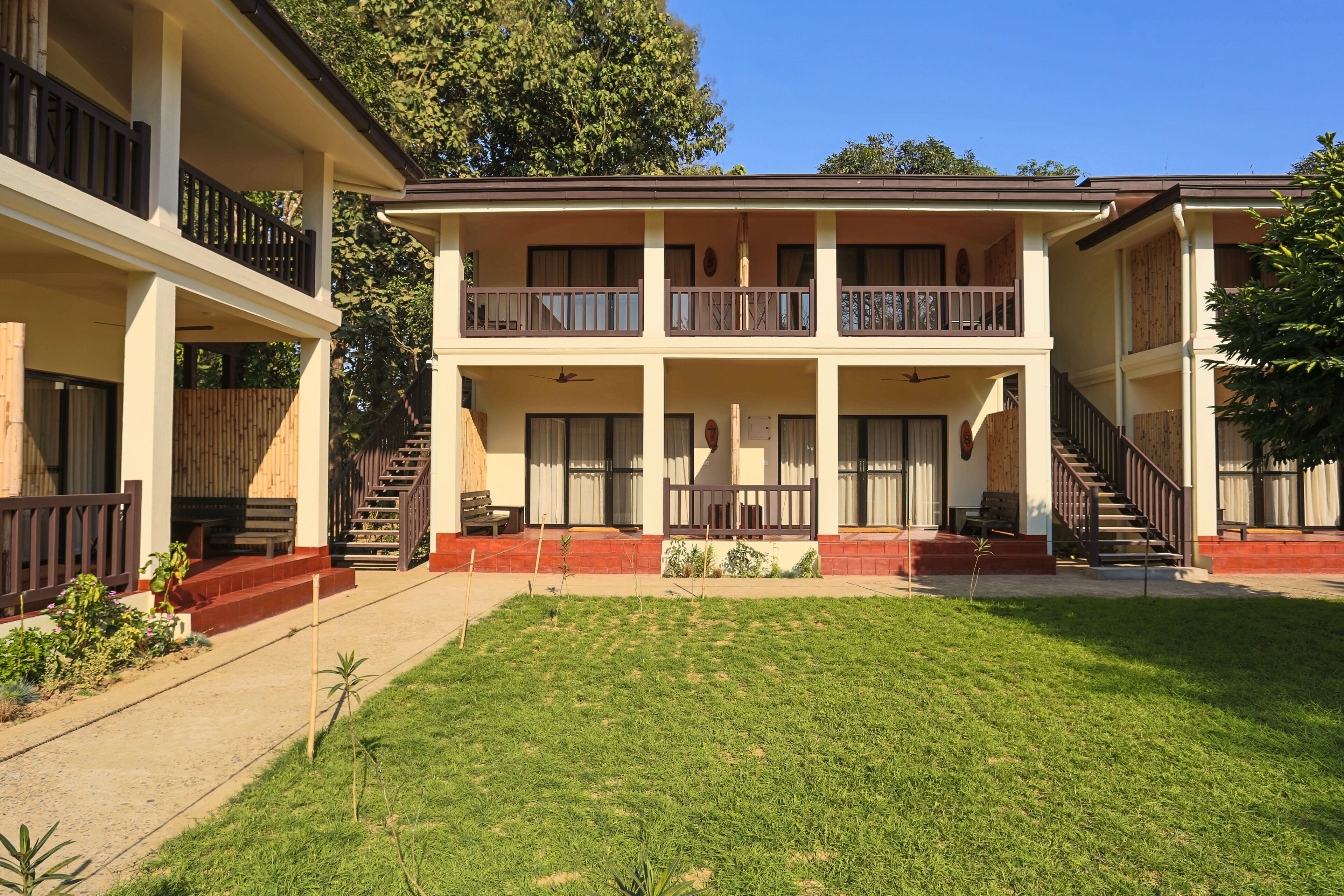 A two-story building with a central courtyard, balconies, and a staircase leading to the upper floor.