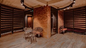 A wine cellar with wooden floors, brick walls, and a circular ceiling light fixture. - Savaneti (Telavi)