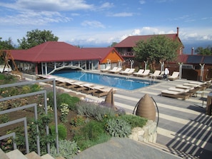 A pool area with lounge chairs and a garden. - Savaneti (Telavi)