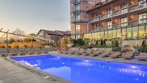 A swimming pool with lounge chairs and a stone wall. - Savaneti (Telavi)