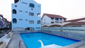Ein Swimmingpool mit einer klaren, blauen Wasseroberfläche, umgeben von einer gefliesten Liegefläche.
