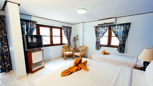 Ein Hotelzimmer mit einem Bett, einem Fernseher, einem Sessel und einem Tisch.