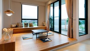 A modern living room with a sofa, a coffee table, and large windows with curtains. - Wei Wei Chu B&B (Zhuangwei)