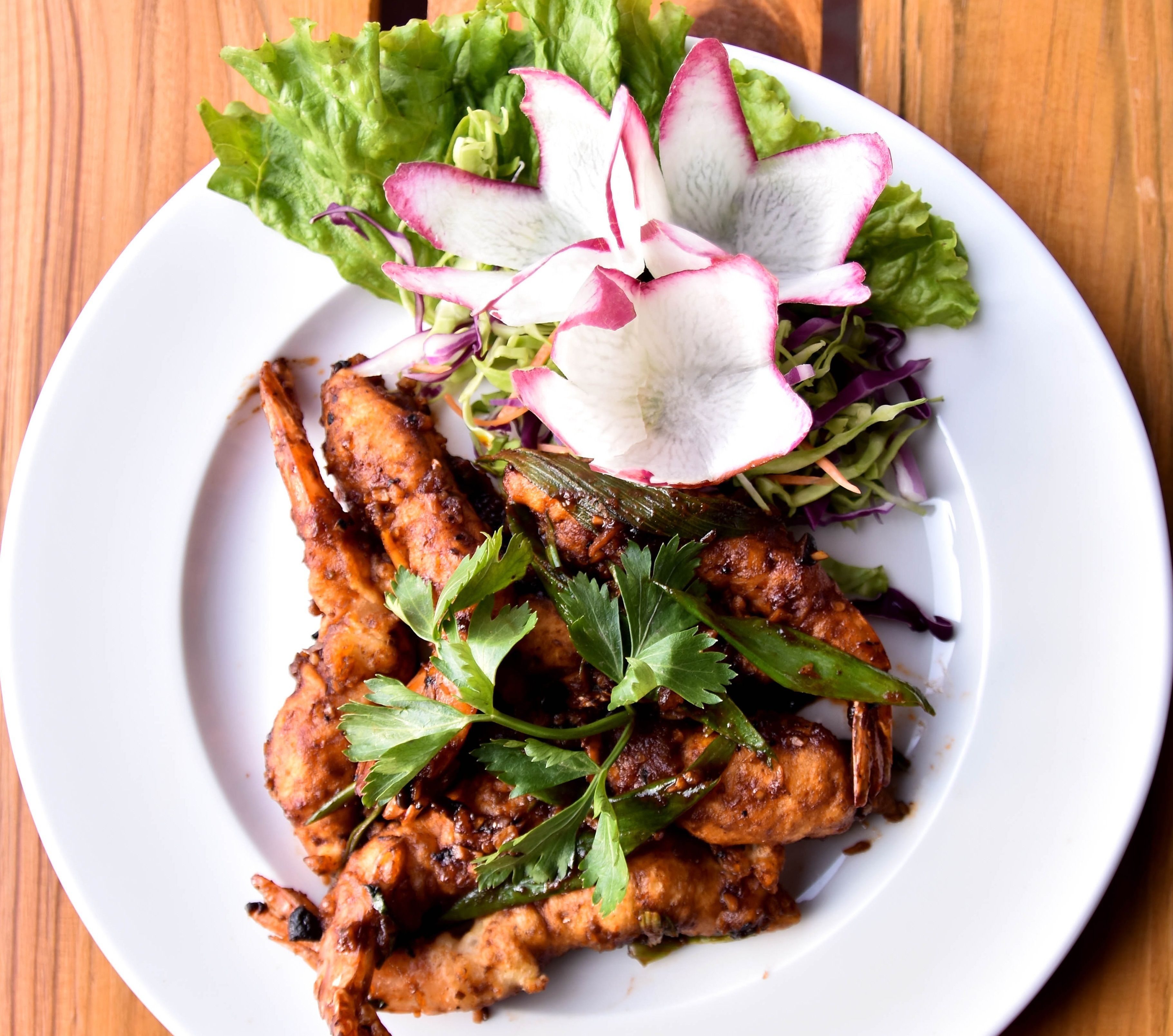 A plate of grilled chicken with vegetables and a side salad.
