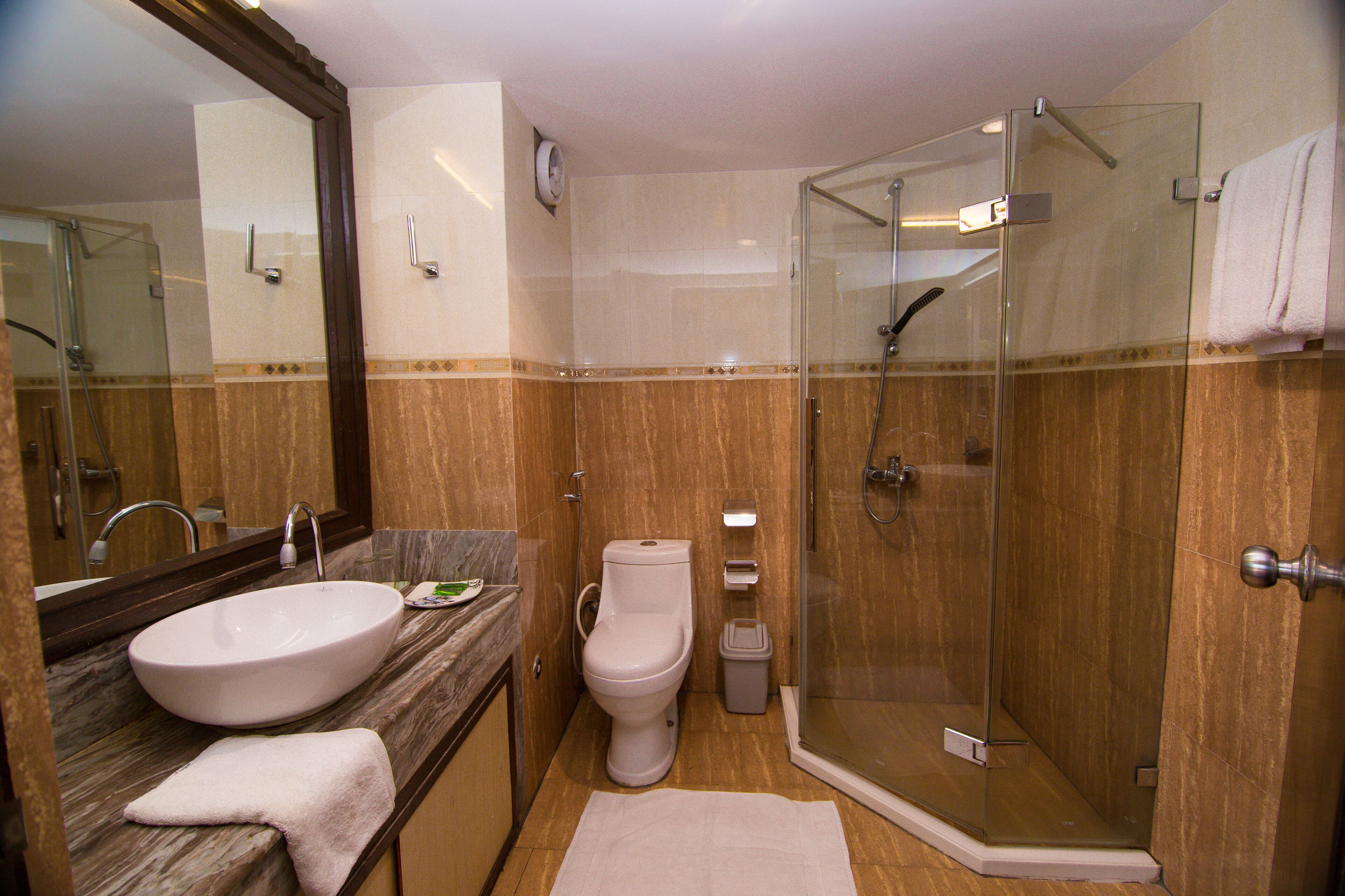 A bathroom with a sink, toilet, and glass-enclosed shower.