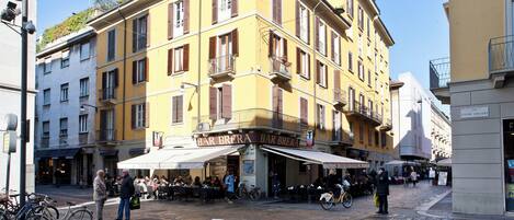 A yellow building with a bar named Bar Brera.