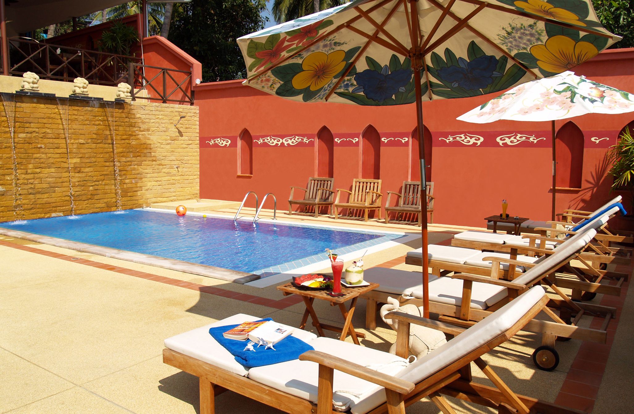 A pool area with lounge chairs and umbrellas.
