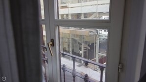 Entrada de un hotel con puerta de vidrio, manija de latón y un letrero que dice 