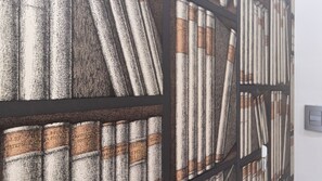A close-up of a textured wall with a grid-like pattern, possibly part of a building's interior design.