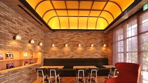 A restaurant with brick walls, wooden herringbone flooring, and a modern seating area with tables and chairs. - Cabinhouse Yado Fujinomiyaten (Fujinomiya)