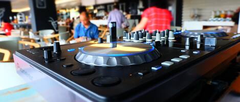 A DJ mixer with a control panel, buttons, and knobs.