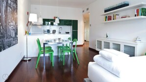 Eine moderne Wohnung mit Küche, Essbereich und Wohnzimmer mit Sofa und Bücherregal.
