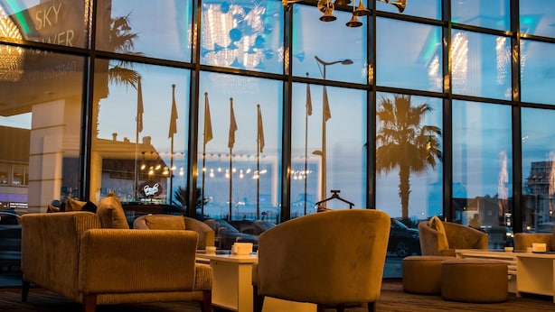 A modern lounge area with comfortable seating and large windows offering views of the cityscape. - Sky Tower Hotel (Batumi)
