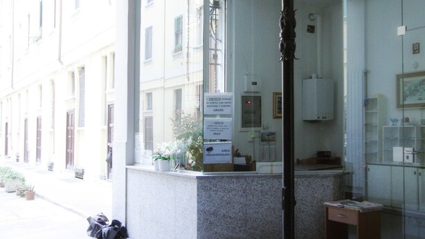 Ein modernes Hotelzimmer mit einem großen Spiegel, einer Hängelampe und Blick auf die Straße.