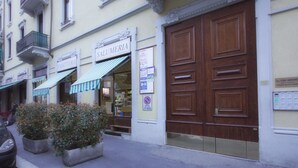 Ein Gebäude mit einer Bäckerei namens "Panetteria" und einer Tür mit einem Verbotsschild für Parkplätze.