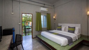 Une chambre à coucher avec un lit, une chaise, un bureau et une fenêtre avec des rideaux.