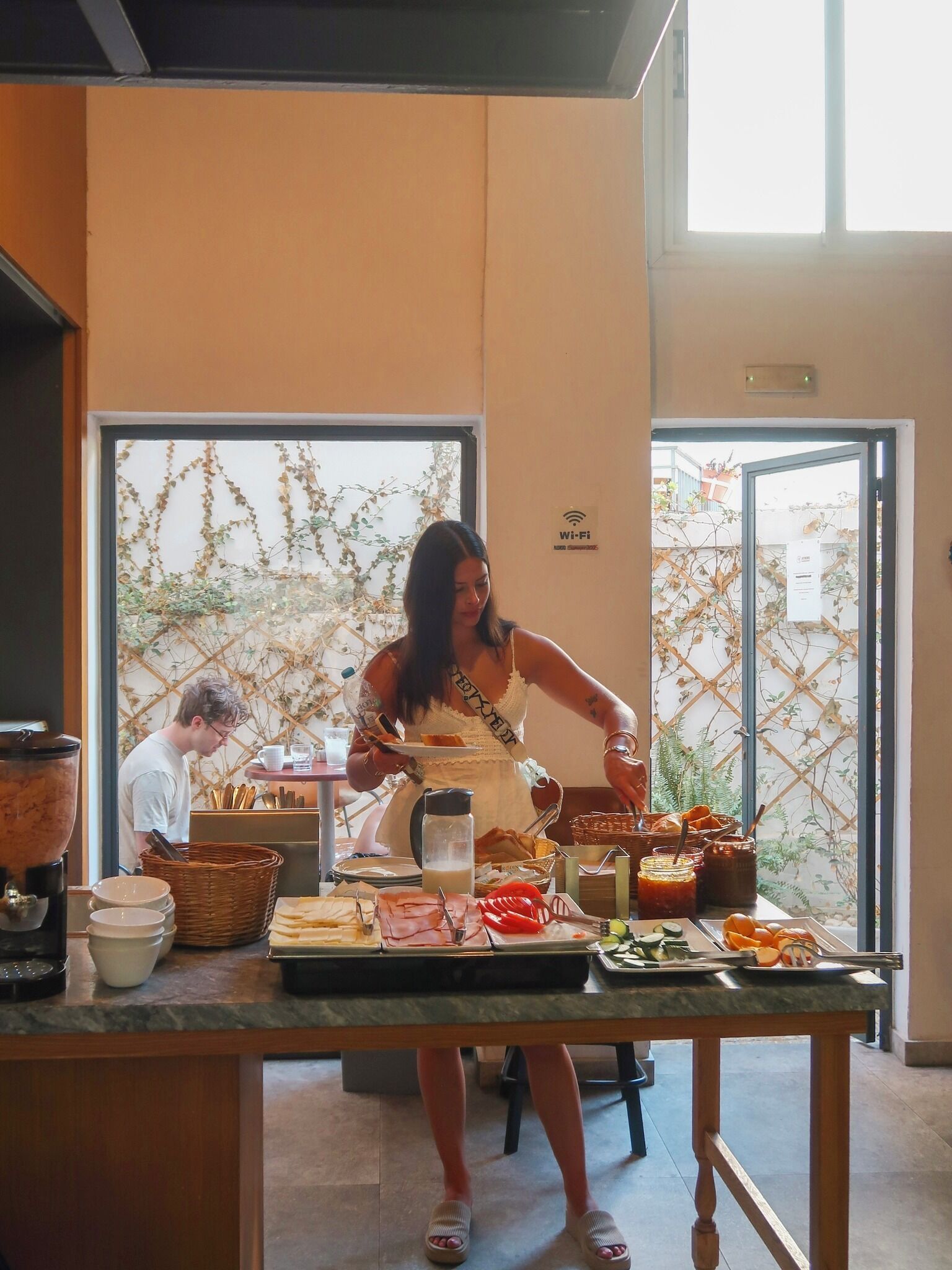 A buffet setup with various food items and a person serving.