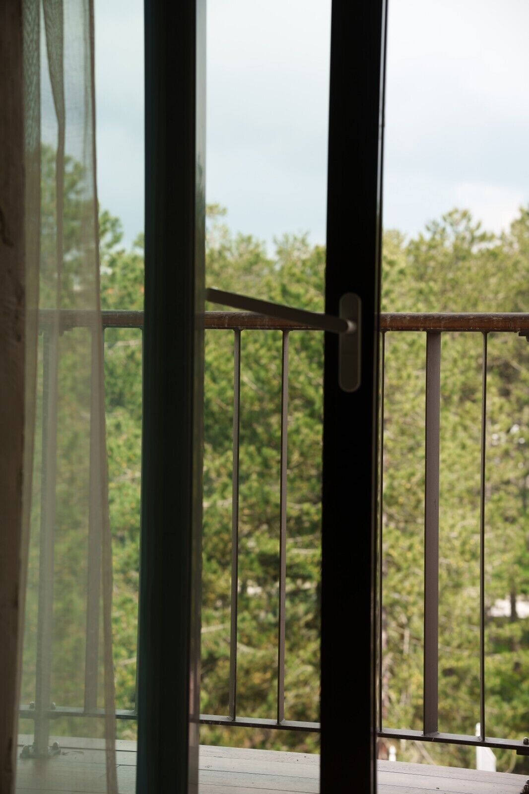 A balcony with a metal railing and a door handle.