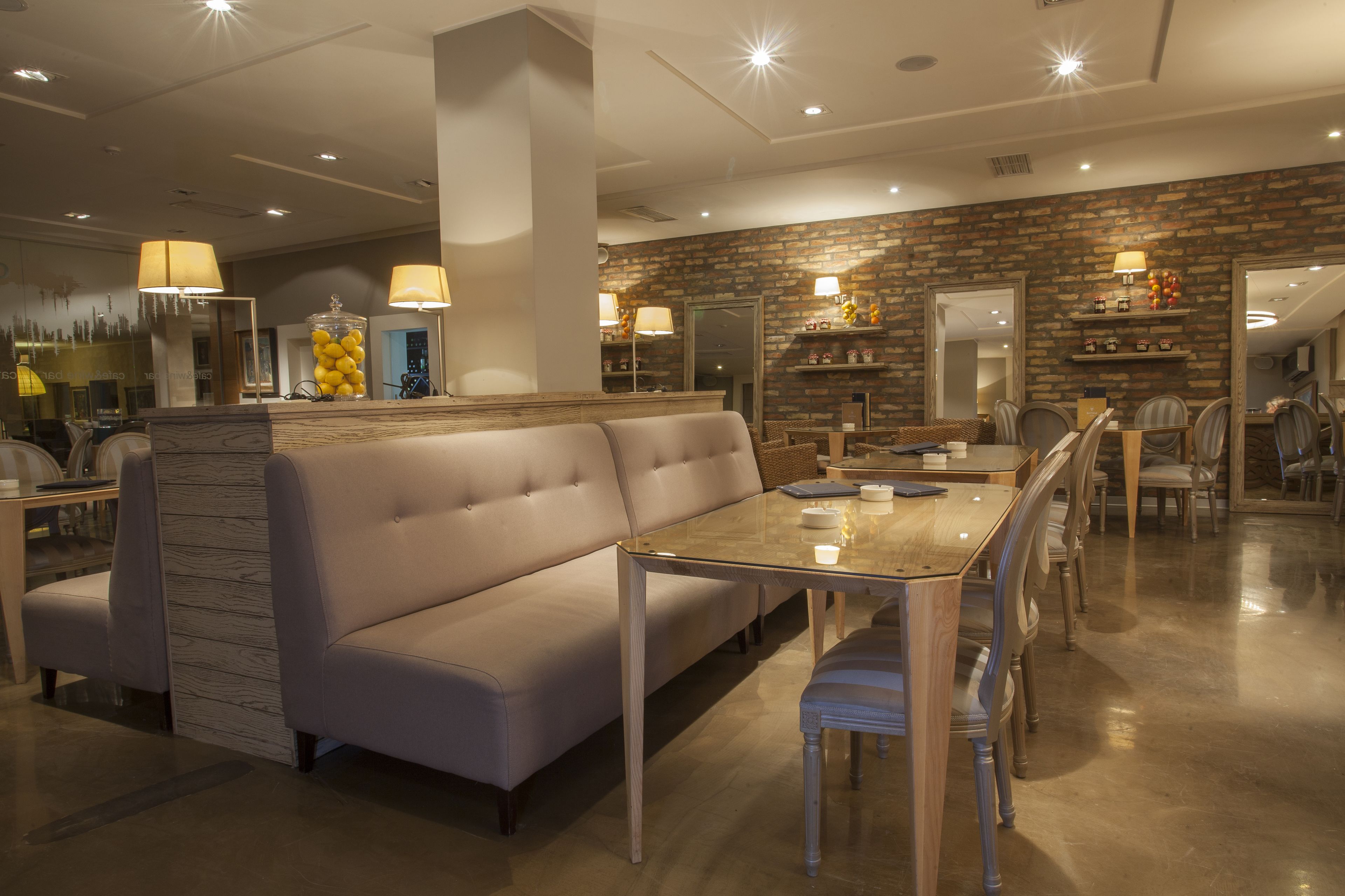 Un comedor moderno con una mesa larga, asientos acolchados e iluminación ambiental.
