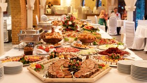 A buffet with various food items and a long table with white tablecloths. - Hotel Palisad (Zlatibor)