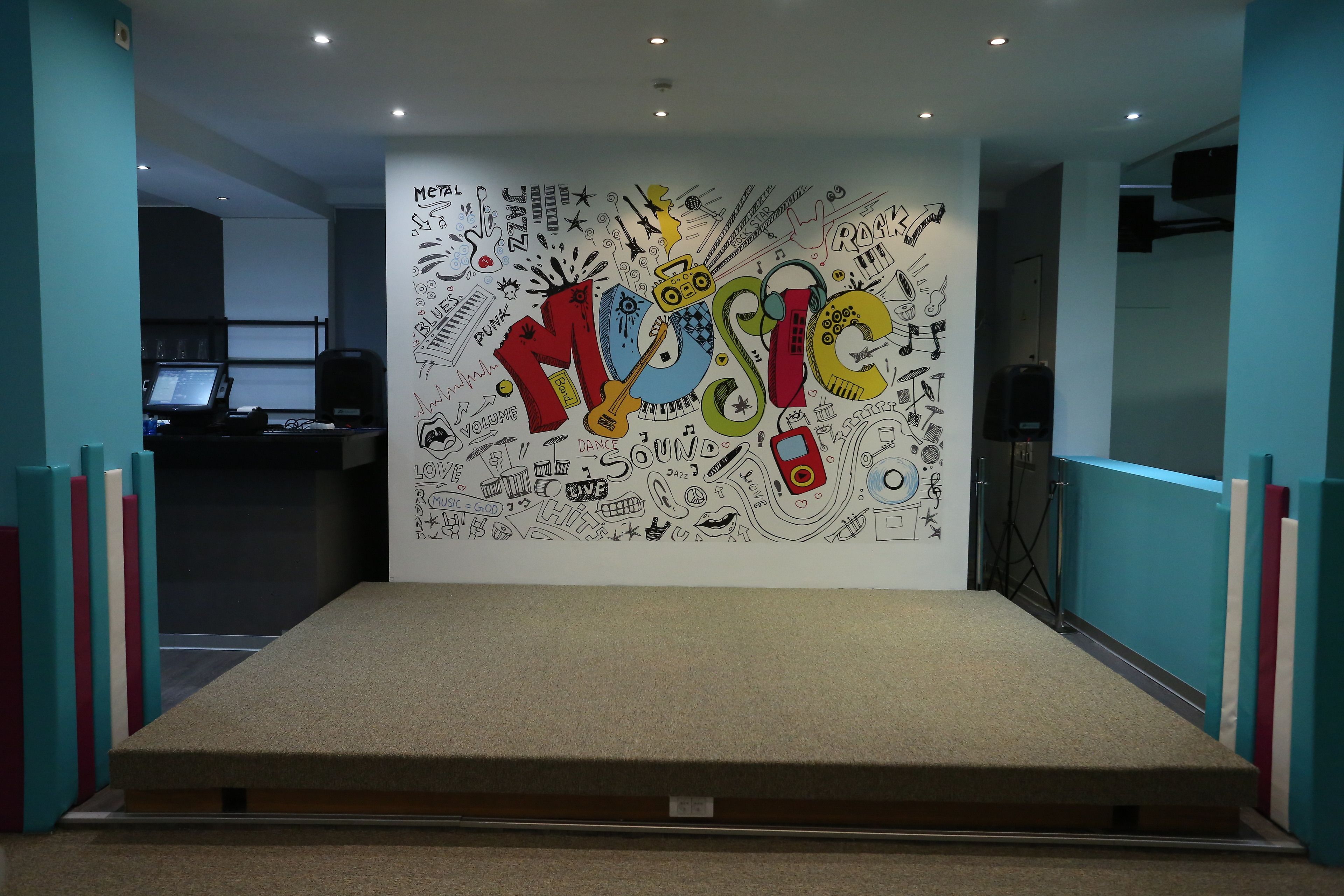 A conference room with a large wall mural featuring musical instruments and the word "MUSIC".
