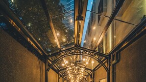 A long, narrow corridor with a wooden table and chairs, leading to a door at the end. - Atour Hotel Jing'an The Drama Shanghai (Shanghai)