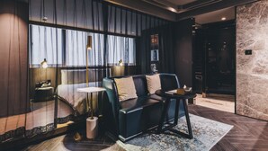 A modern hotel room with a large bed, a sofa, a small table, and a large window with curtains. - Atour Hotel Jing'an The Drama Shanghai (Shanghai)