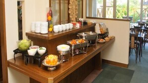 A buffet setup with various food items and a coffee station.