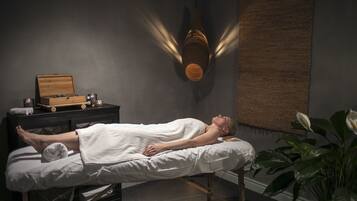 Guests can unwind in a serene spa setting with a treatment bed, surrounded by a calming atmosphere.