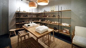 A room with wooden furniture, shelves with various items, and a table with towels.