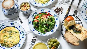 A table with various dishes including a salad, bread, and a cup of coffee.
