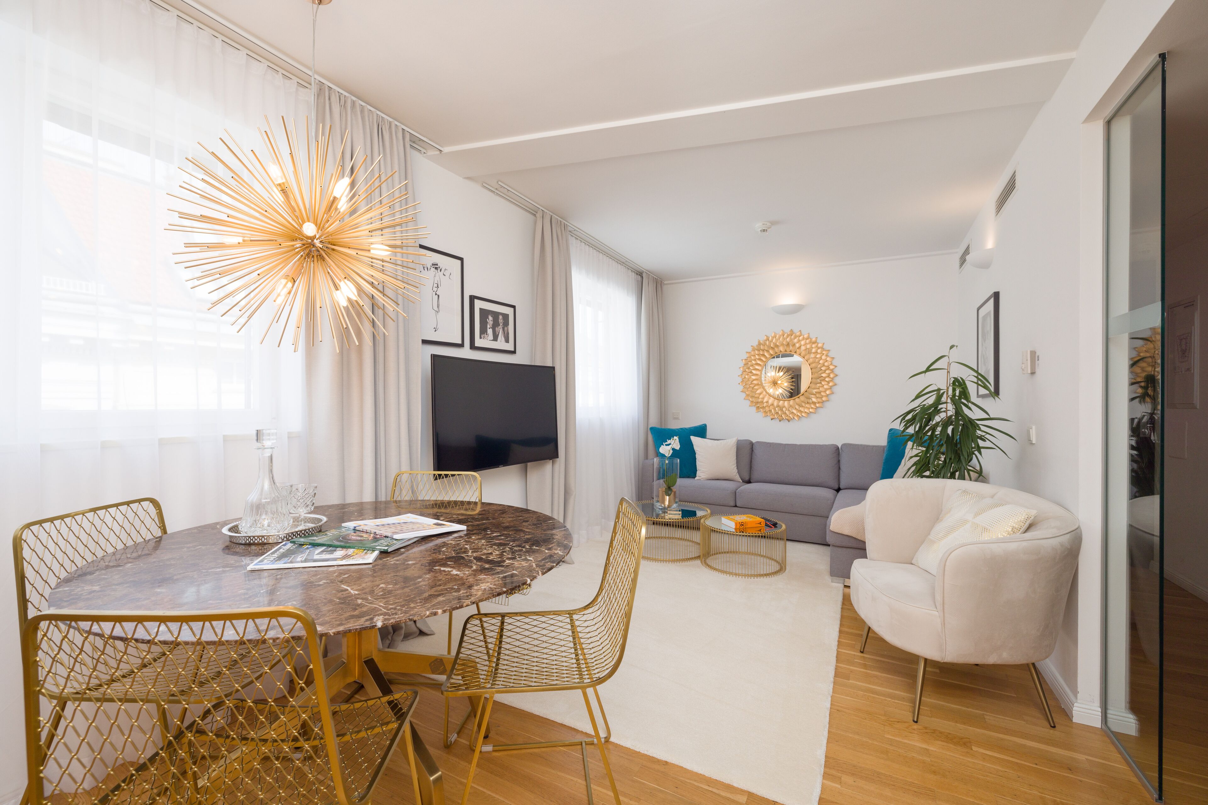 Una sala de estar moderna con una mesa de comedor redonda, un sofá y un televisor.