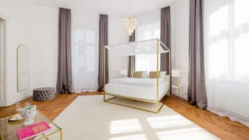 A modern bedroom with a four-poster bed, a glass coffee table, and a large window with curtains.