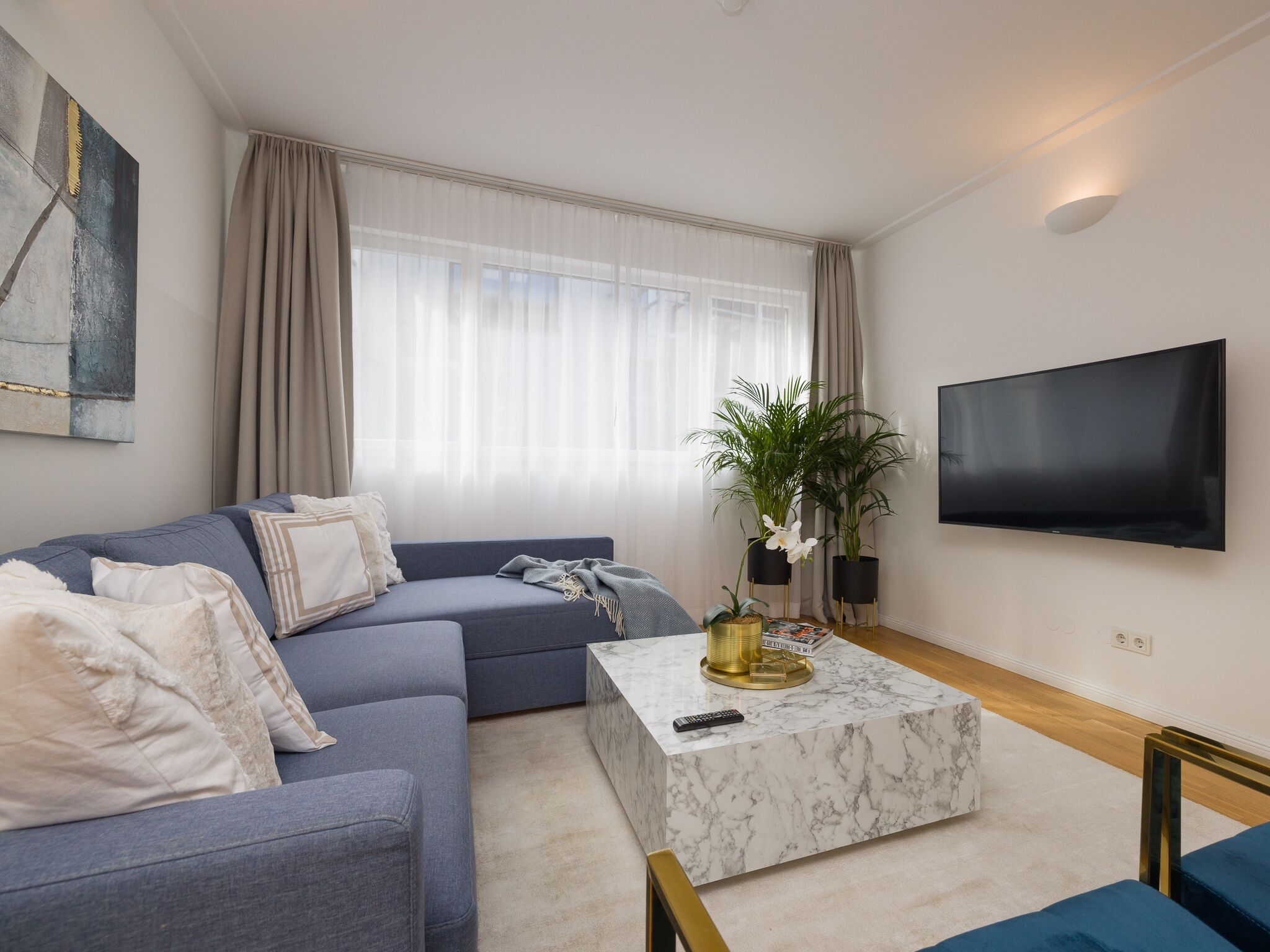 Una sala de estar moderna con un sofá, una mesa de centro y un televisor.