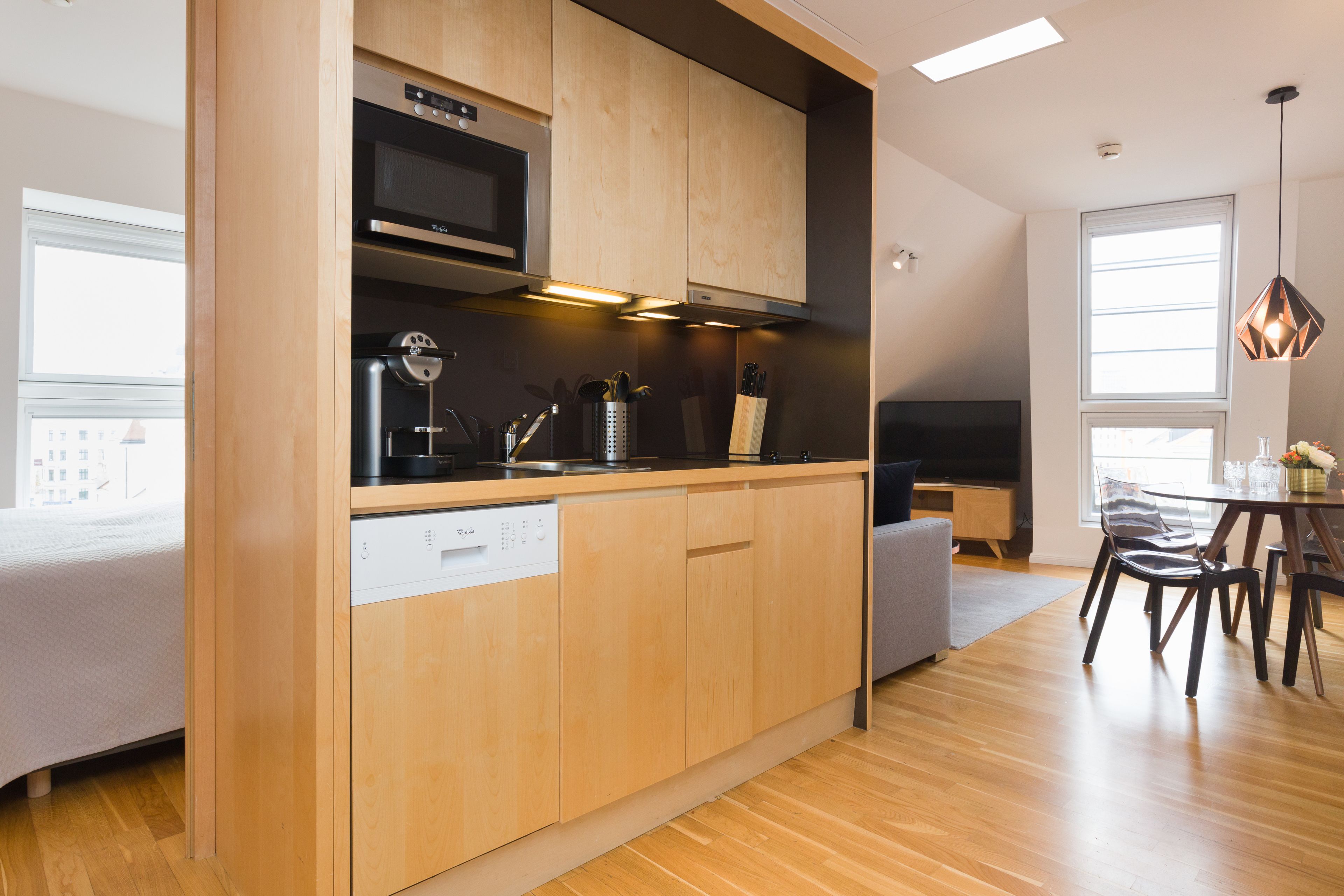 A modern kitchen with wooden cabinets, a dishwasher, and a microwave.