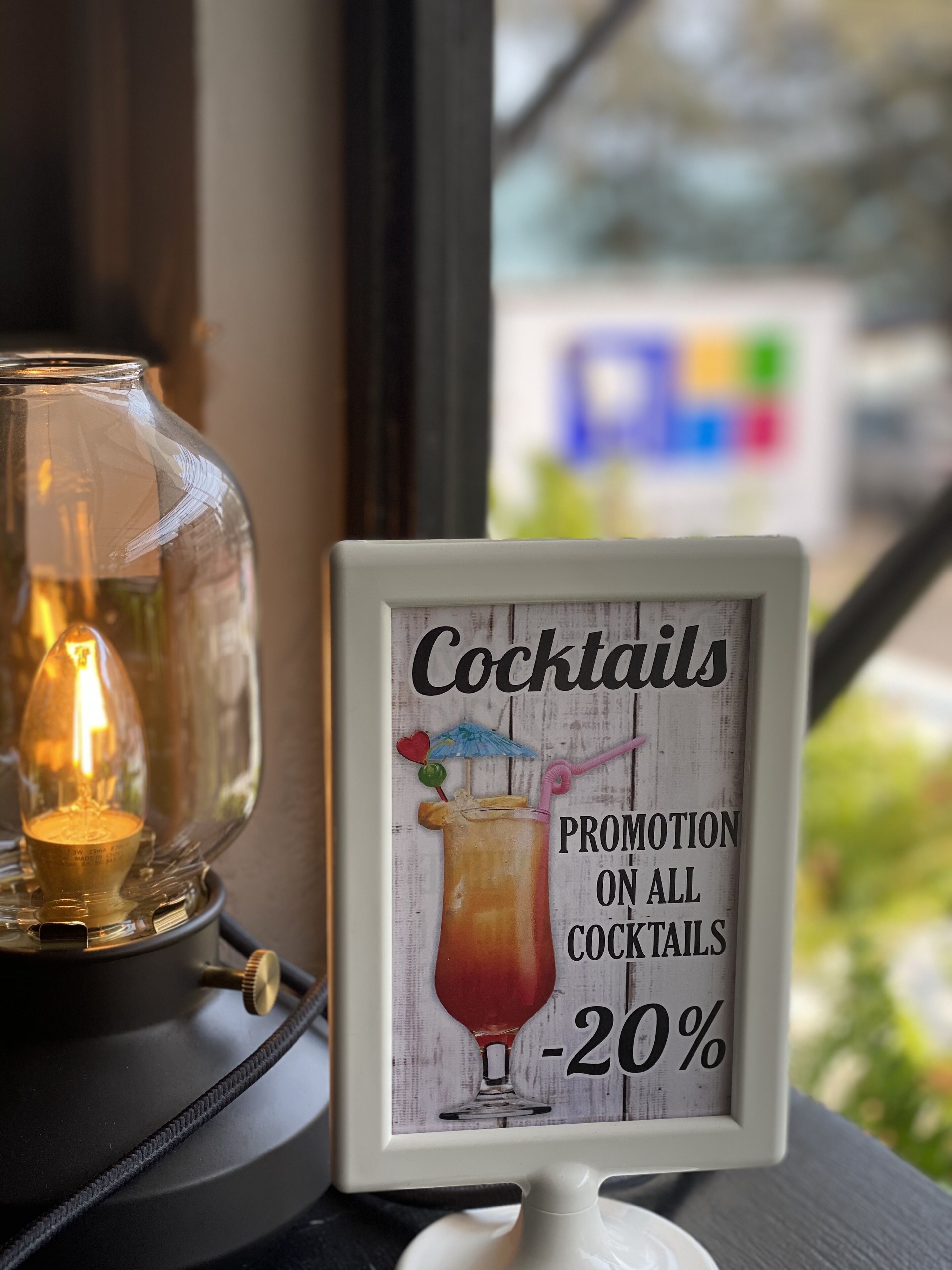 Un cartel enmarco con una promoción de cócteles: 20% de descuento.