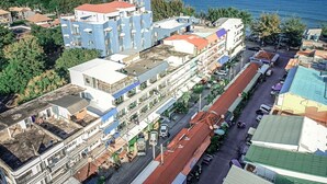An aerial view of a coastal town with buildings, a street, and a view of the sea. - The Beach Cha Am Residence (Cha-am)