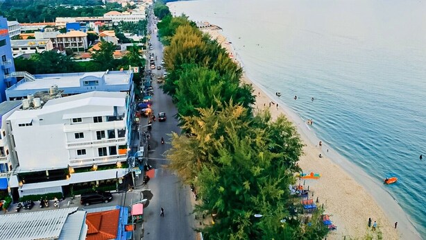 A coastal cityscape with a beach, buildings, and a road along the shore. - The Beach Cha Am Residence (Cha-am)