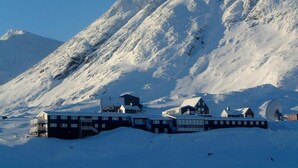 Une montagne enneigée, avec un hôtel appelé « Hôtel Angmagdaleni » au premier plan.