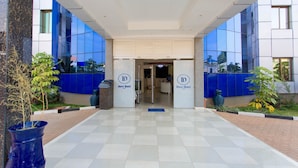 The entrance of Dove Hotel with a checkered floor, glass facade, and a reception desk.