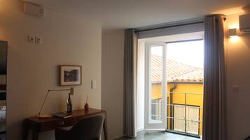 A room with a desk, chair, and a window with curtains.