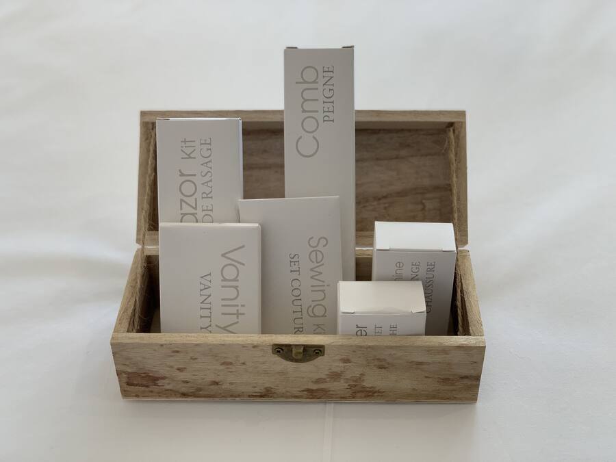 Una caja de madera que contiene varios objetos rectangulares blancos con texto, probablemente embalaje para productos.