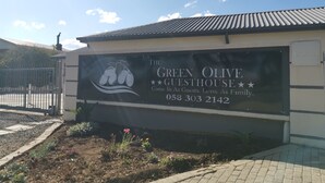 A sign for The Green Olive Guesthouse with contact information. - The Green Olive Guesthouse (Bethlehem)