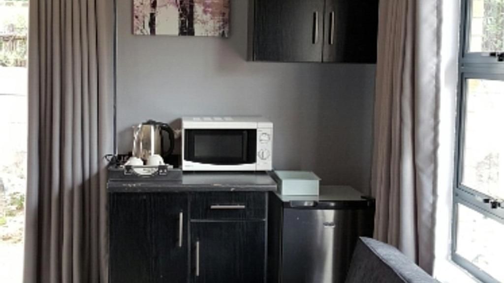A compact kitchenette with a microwave, coffee maker, and a small refrigerator.