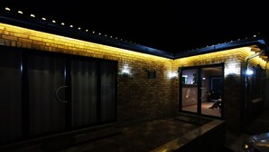A building with a brick exterior and a glass door entrance. - The Green Olive Guesthouse (Bethlehem)