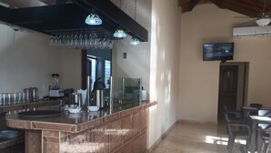 Una cocina con una isla central, un refrigerador y un televisor montado en la pared.