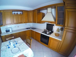 Full-size fridge, oven, stovetop, cookware/dishes/utensils