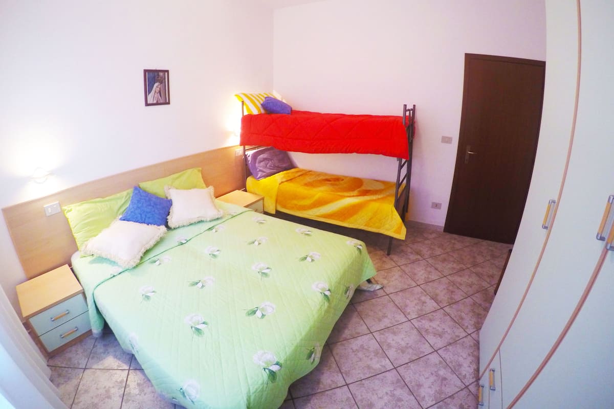 Ein Schlafzimmer mit zwei Betten, einem Kleiderschrank und einem Nachttisch.