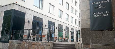 Una entrada a un edificio con un cartel que dice "OCAK APARTMENT & HOTEL" a la derecha.
